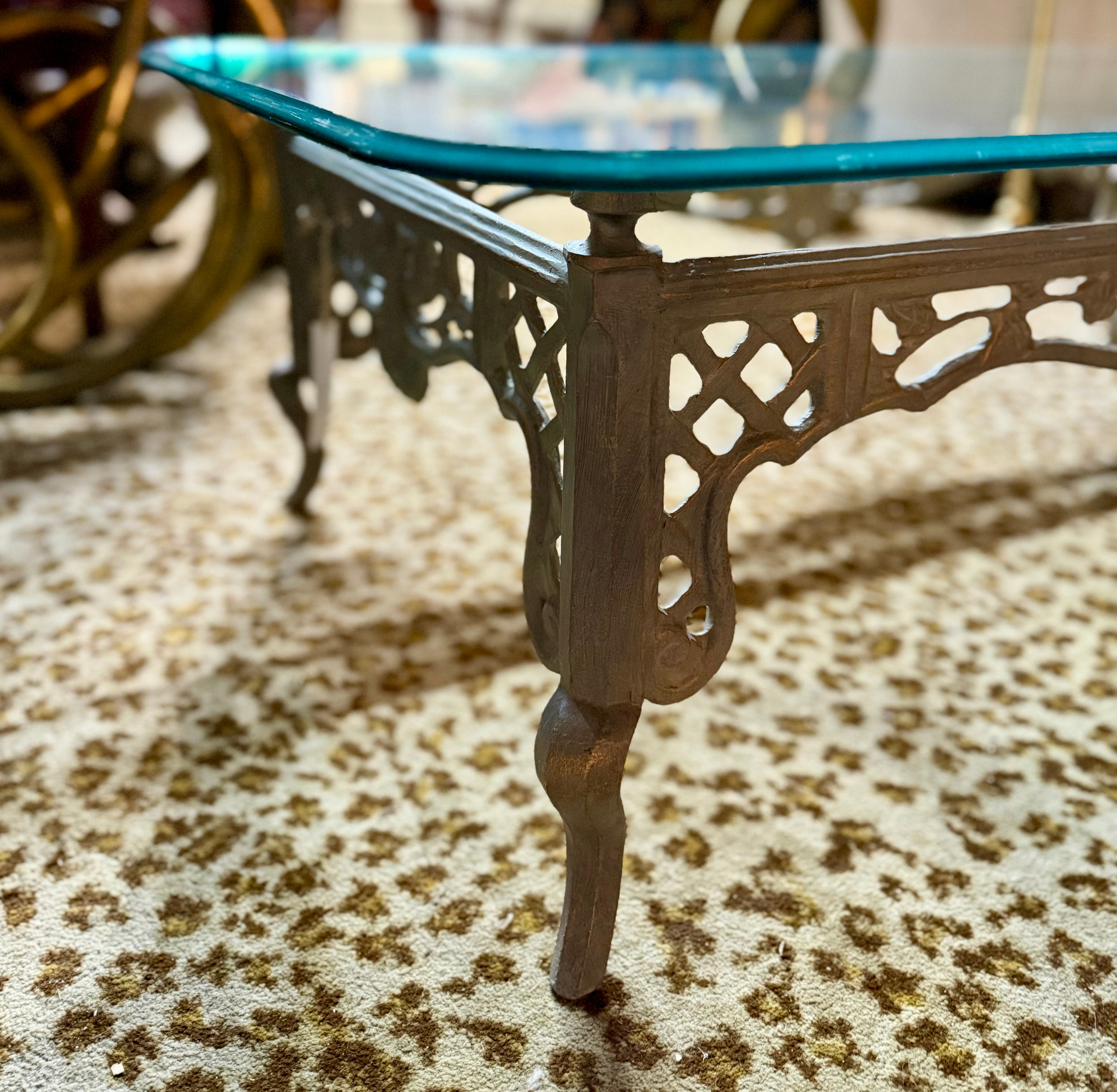 Decorative coffee table with intricate metal legs on a patterned carpet